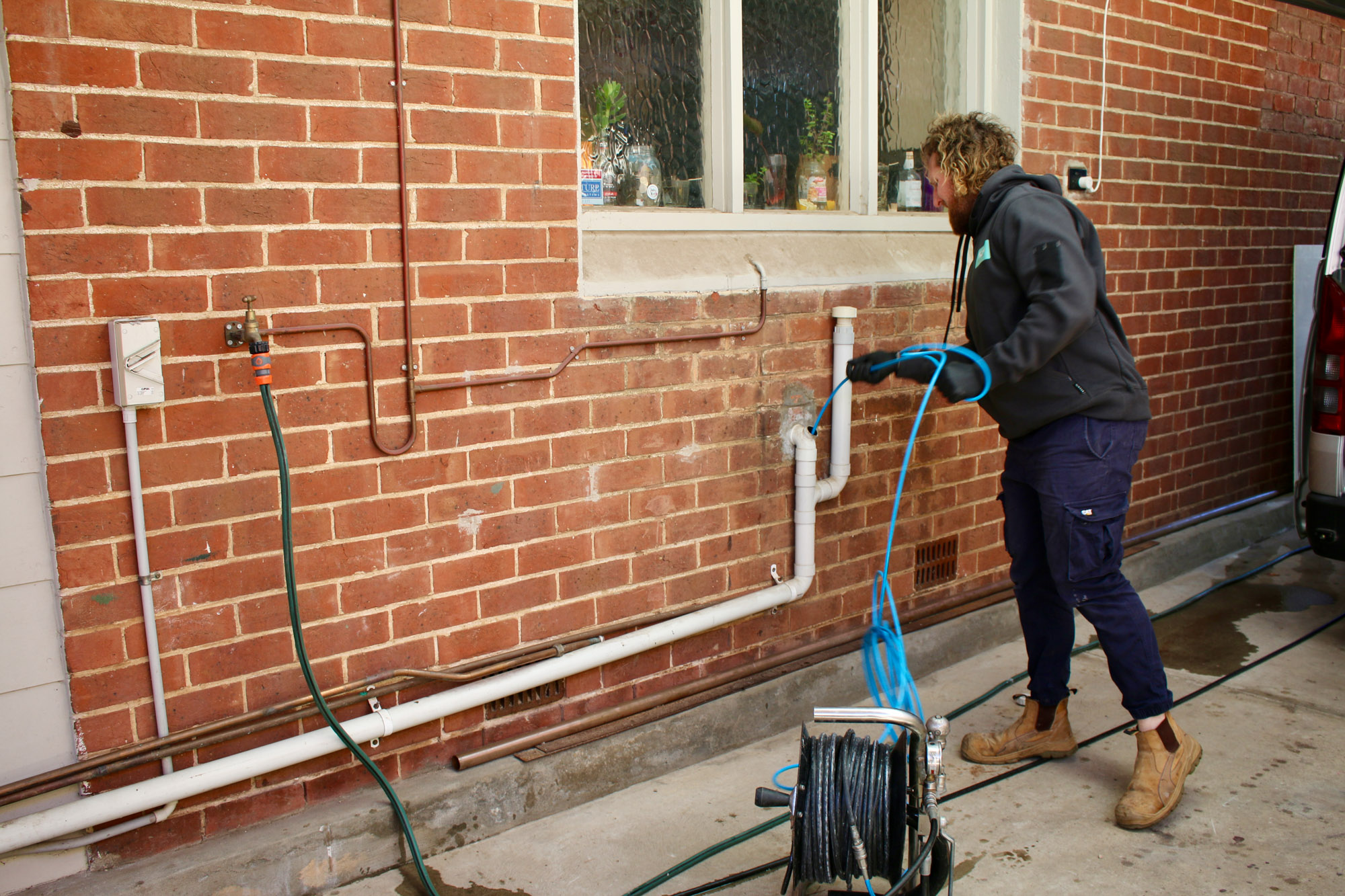 Koala Plumbing qualified trade with an electric drain cleaner in Adelaide