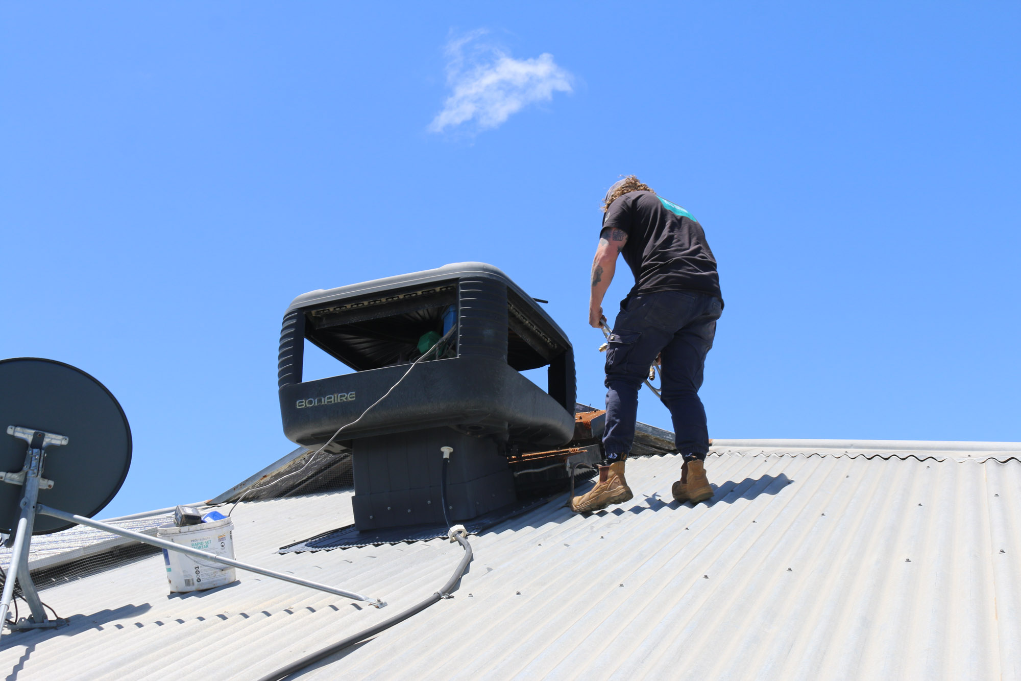 Koala Plumbing qualified trade installing an air conditioner on a roof